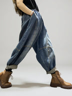 Side view of oversized patchwork denim harem pants showing the relaxed balloon fit.