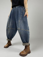 Front view of relaxed fit patchwork denim harem pants with elastic waistband.