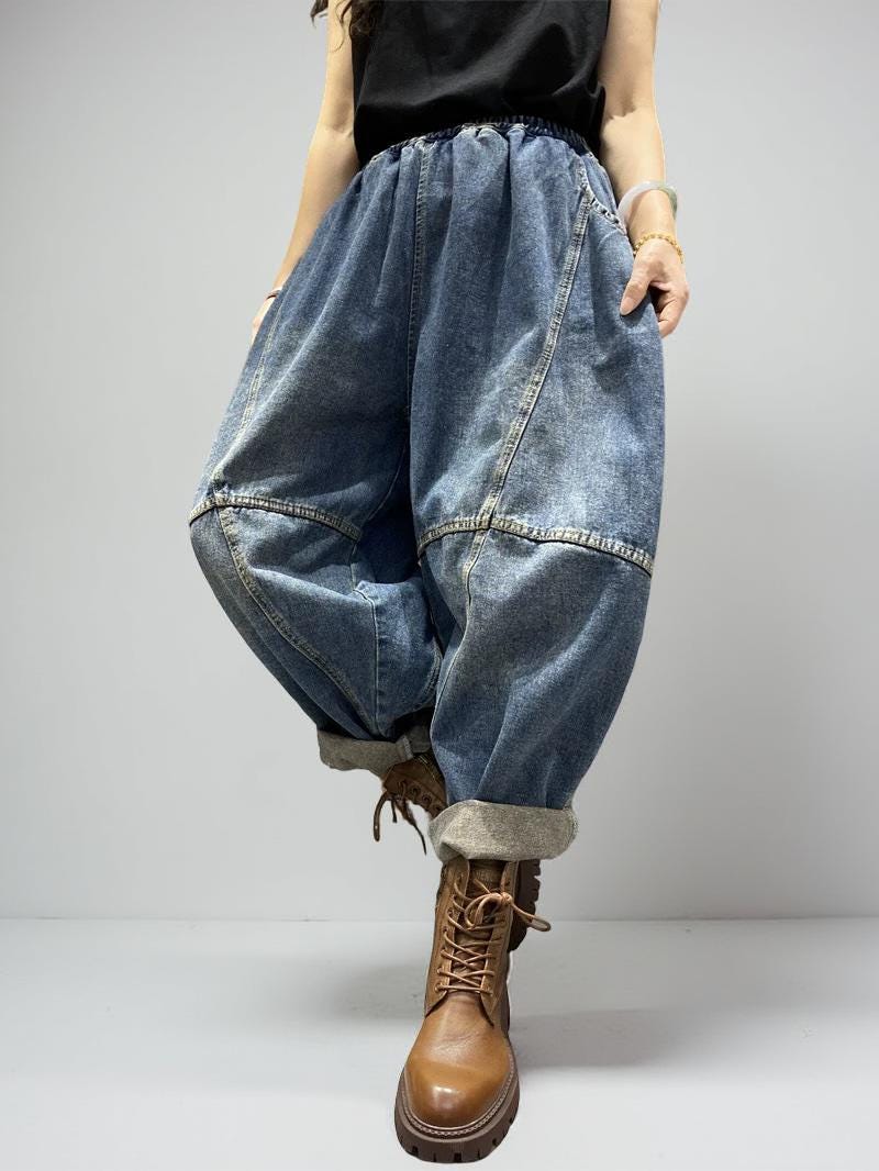 Model walking in oversized patchwork denim balloon pants with cuffed hems.
