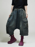 Model wearing oversized vintage washed denim cargo harem pants with elastic drawstring waist.