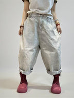 Front view of vintage washed baggy denim pants with rolled hems.