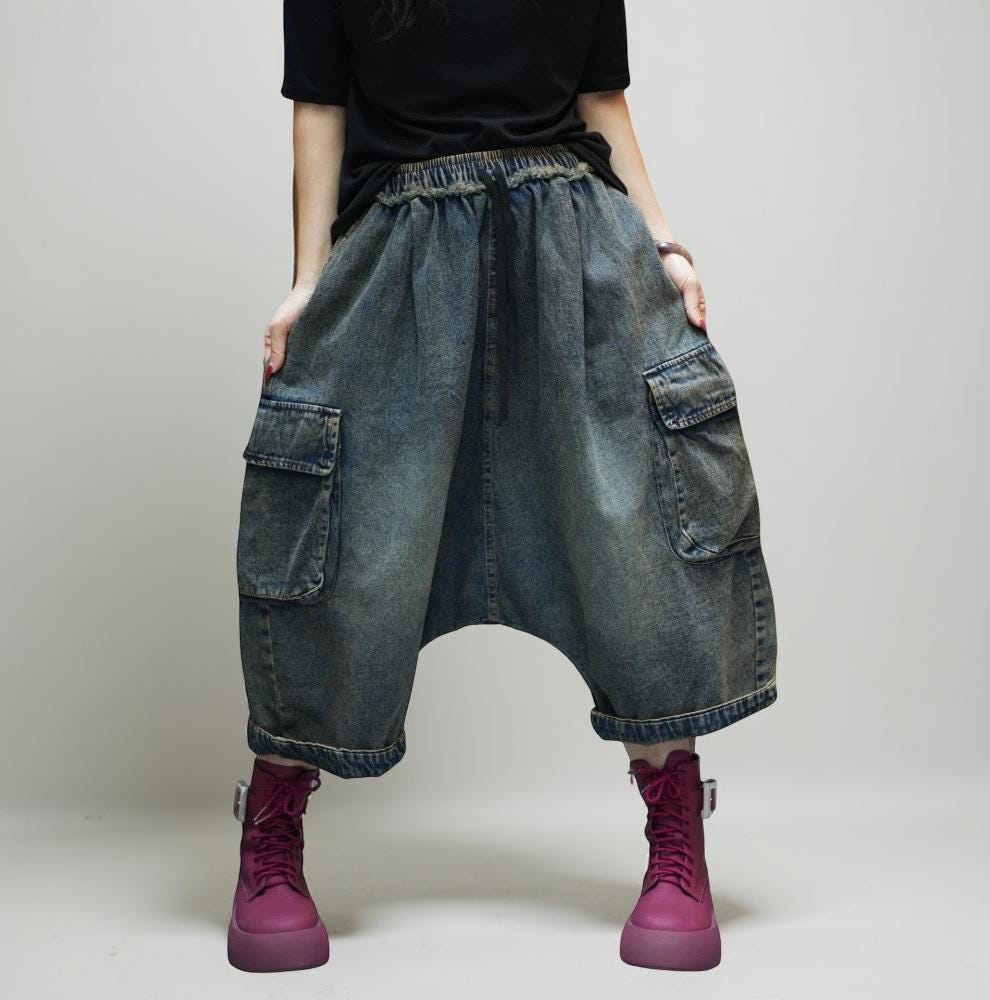 Model wearing vintage washed 100% cotton denim cargo harem pants with oversized drop-crotch silhouette and utility pockets.
