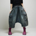 Model wearing vintage washed 100% cotton denim cargo harem pants with oversized drop-crotch silhouette and utility pockets.