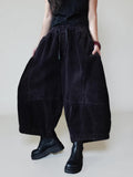 Side view of oversized corduroy harem pants showing the balloon silhouette.