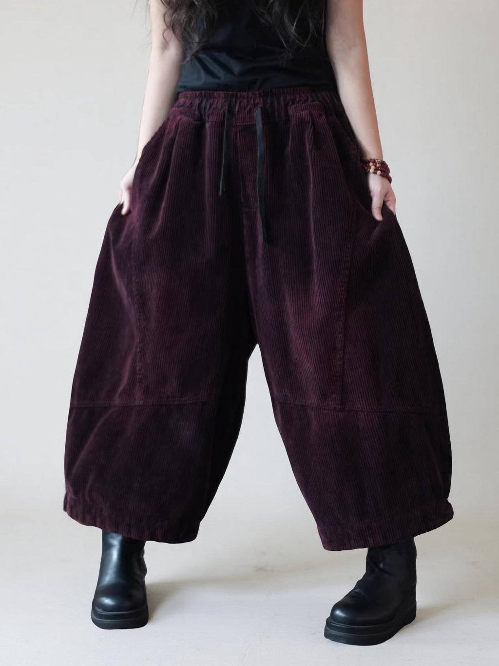 Oversized burgundy corduroy harem pants with cropped balloon legs.