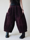 Oversized burgundy corduroy harem pants with cropped balloon legs.