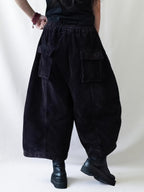 Back view of oversized corduroy balloon pants with an elastic waistband.