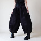 Oversized black corduroy balloon harem pants with elastic waist and cropped wide legs.