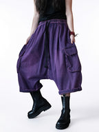 Purple vintage washed denim cargo harem pants with oversized drop-crotch silhouette.