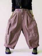 Front view of oversized dusty pink cargo balloon pants with a high waist.