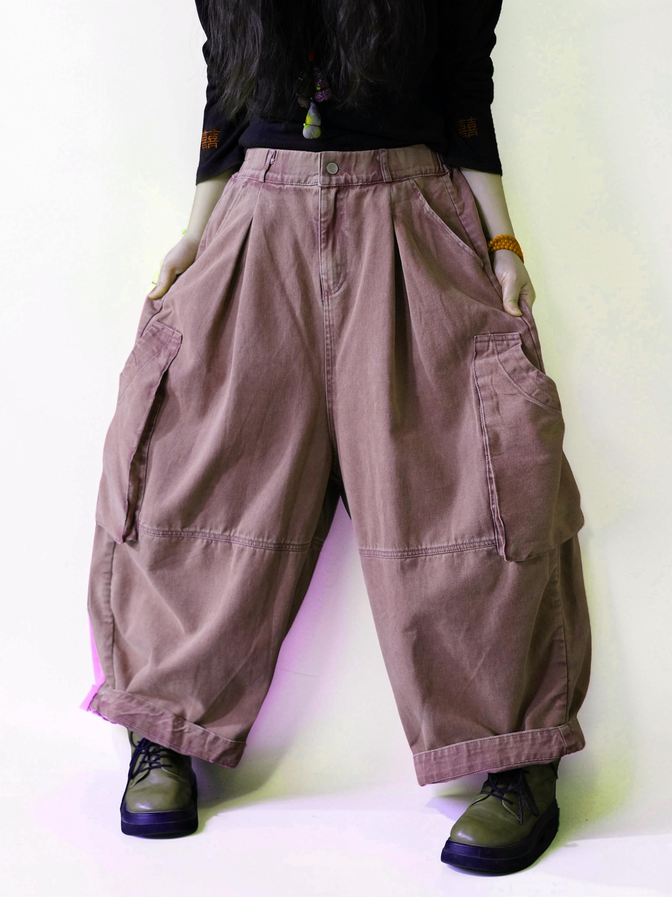 Side view of oversized dusty pink cargo balloon pants with a high waist.