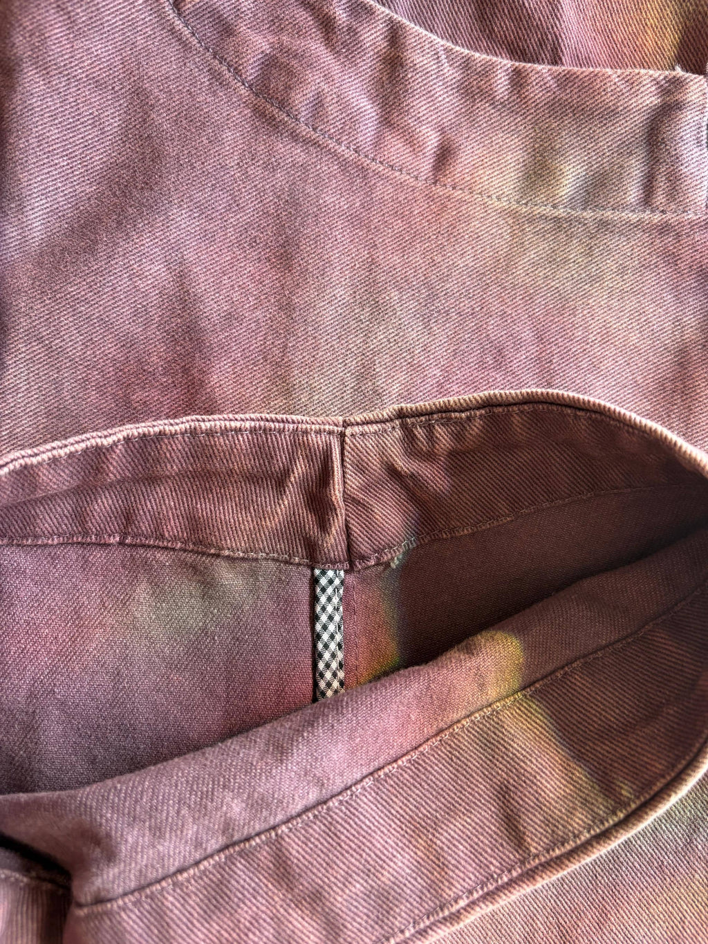 Close-up of vintage washed cotton fabric with rich tonal variation, artisan-dyed color shifts, and detailed stitching.