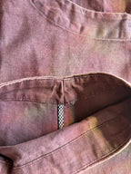 Close-up of vintage washed cotton fabric with rich tonal variation, artisan-dyed color shifts, and detailed stitching.